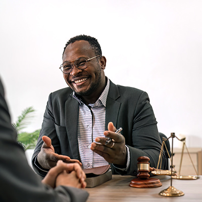 A black lawyer in a suit speaks to a client