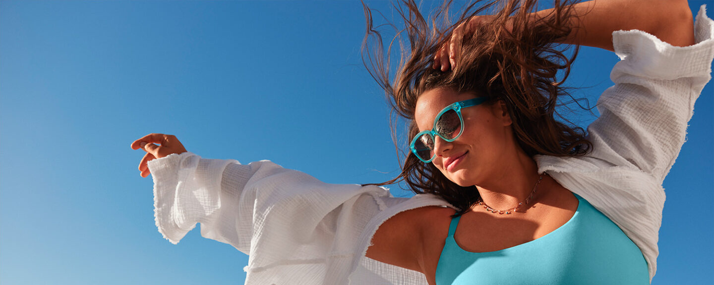 A young woman smiles while dancing in the sunshine