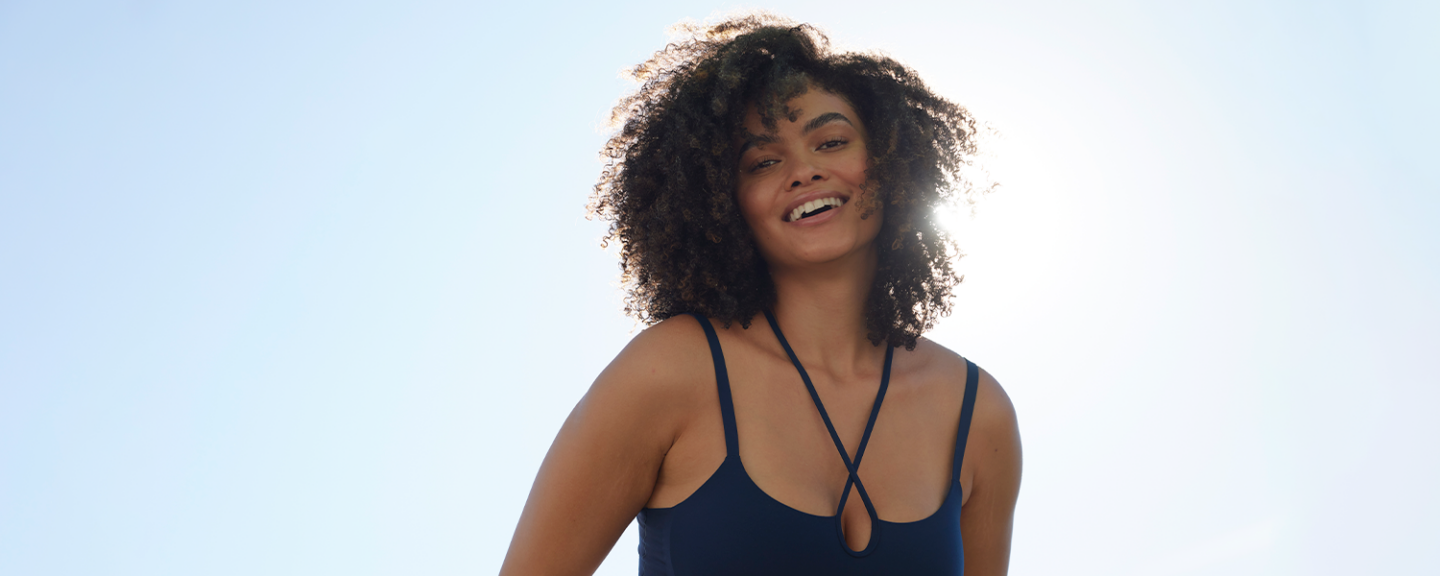 A young black woman smiles in the sunshine