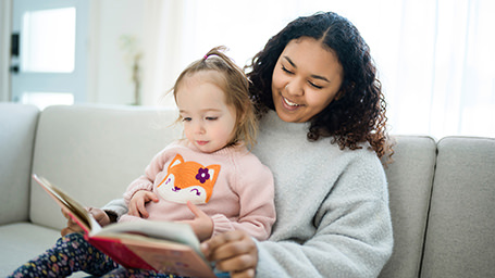 A black woman reads to her young foster child