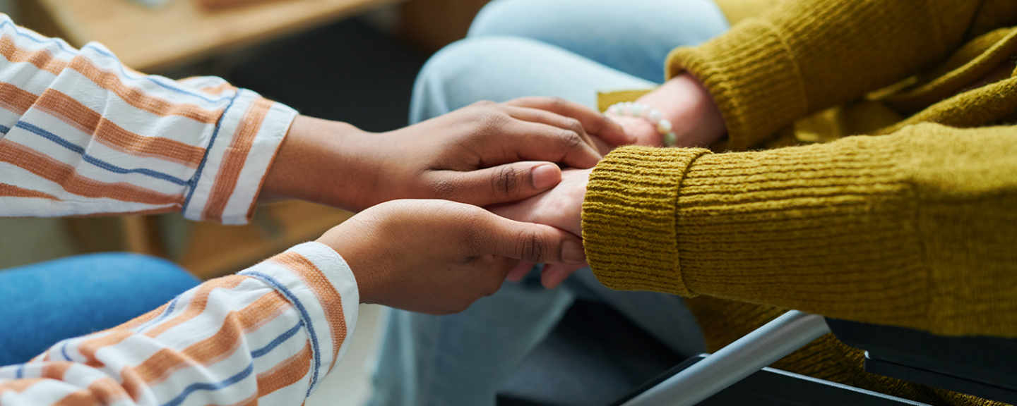 Two people hold hands