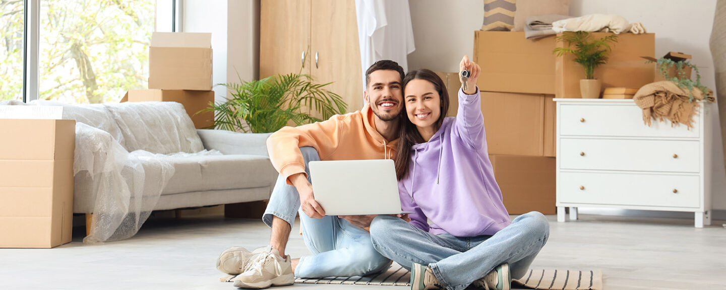 A happy couple hold the keys to their new home