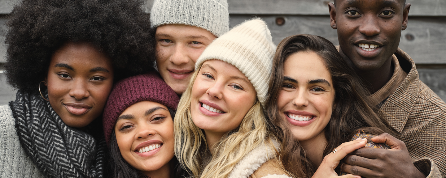 A group of six friends embrace